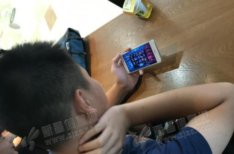 小孩拿着手机打游戏图片-小孩沉迷手机游戏：危害大过你想象